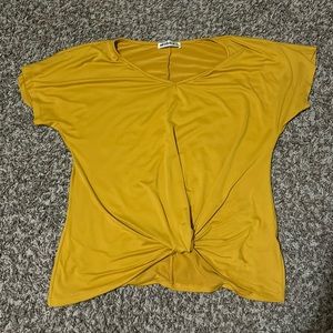 gold doublju shirt with knot at the bottom
